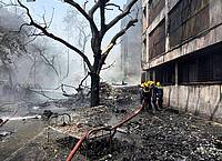Ajit Solanki/AP/dpa | Feuerwehrleute arbeiten an der Absturzstelle.