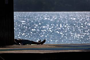 Karl-Josef Hildenbrand/dpa | Ausflügler genießen auf dem Steg des Strandbades am Ammersee in Bayern den Sonnenschein.