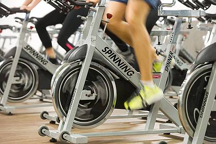 Tobias Hase/dpa-tmn | Indoorcycling statt Rennradrunde draußen: Bei Sommerhitze ist es sinnvoll, das Training ins gut klimatisierte Fitnessstudio zu verlegen. 