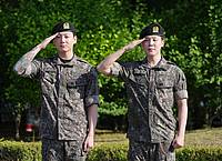 Lee Jin-man/AP/dpa | Die Mitglieder der K-Pop-Band BTS, Jimin (r) und Jung Kook, salutieren nach ihrer Entlassung aus dem Militärdienst.