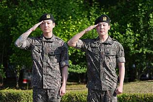 Lee Jin-man/AP/dpa | Die Mitglieder der K-Pop-Band BTS, Jimin (r) und Jung Kook, salutieren nach ihrer Entlassung aus dem Militärdienst.