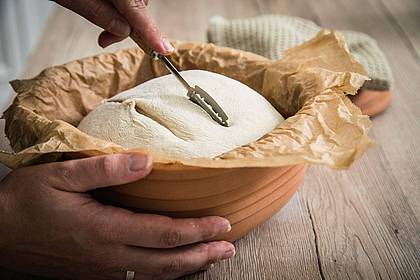 Christin Klose/dpa-tmn | Sauerteig für Weizenbrot kann im Römertopf gebacken werden und wird vor dem Backen eingeschnitten. 
