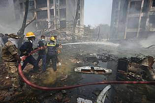 Ajit Solanki/AP/dpa | Feuerwehrleute sind im Einsatz.