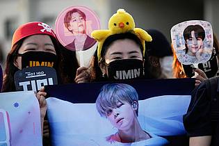 Lee Jin-man/AP/dpa | Fans warten auf die Ankunft der Mitglieder der K-Pop-Band BTS, Jimin und Jung Kook.