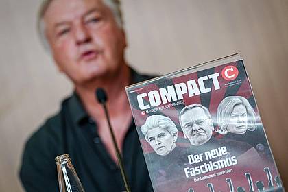 Kay Nietfeld/dpa | «Compact»-Chefredakteur Jürgen Elsässer hinter einem Titelbild seines Magazins. (Archivbild) 