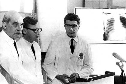 Klaus Heirler/dpa | Die Münchner Chirurgen Rudolf Zenker (l), Werner Rudolph (m) und Werner Klinner (r) bestätigen am 14. Februar 1969 vor Journalisten, dass am 13. Februar 1969 die erste Herztransplantation in der Bundesrepublik durchgeführt wurde. (Archivbild)
