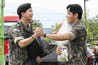 -/kyodo/dpa | Die Sänger RM (l) und V der südkoreanischen Band BTS sind nach 18 Monaten aus dem Militärdienst entlassen worden. 